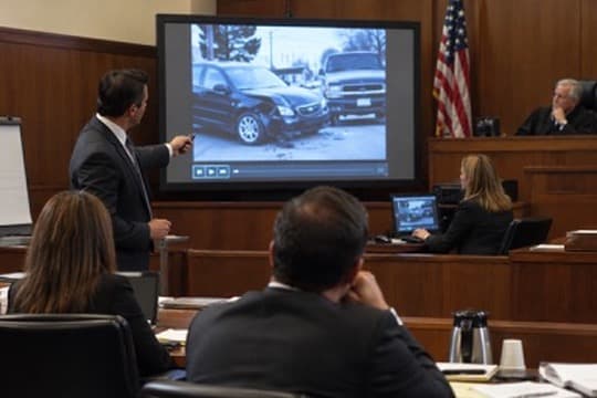 Trial technician presenting video evidence on a courtroom display