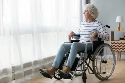 A wheelchair user seated beside a window at home