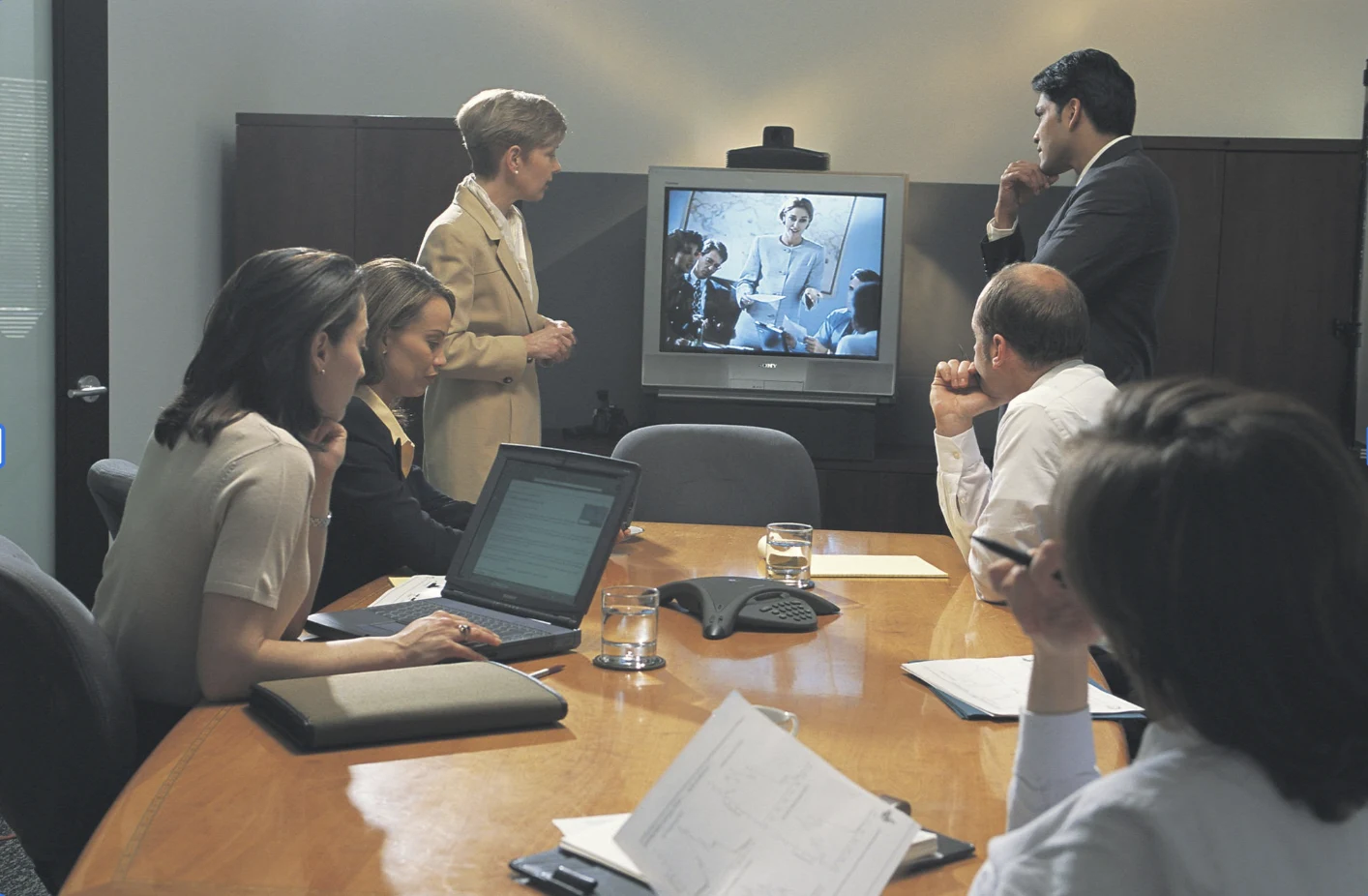 Legal professionals in a conference room participating with a remote deposition attendee